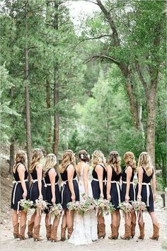 a group of women standing next to each other in front of trees and dirt ground