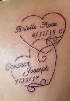 the back of a woman's shoulder with a heart and name tattoo on it