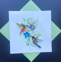 a card with two hummingbirds and flowers on it