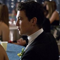 a man in a tuxedo sitting at a table