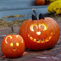 two pumpkins with faces carved to look like jack - o'- lanternes