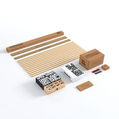 an assortment of wooden items including pencils, erasers and matchessticks on a white surface