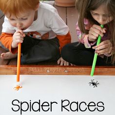 two young children sitting on the ground and one is holding a toothbrush in their mouth