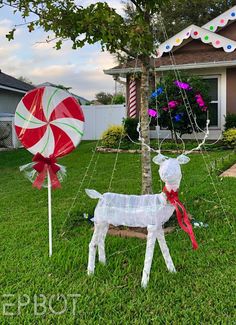 a yard decorated for christmas with candy canes and paper mache goats on the lawn