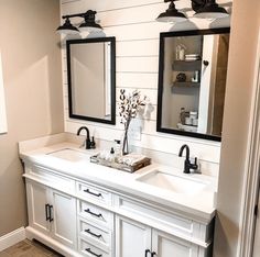 a bathroom with double sinks and two mirrors