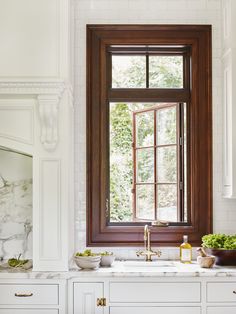 a kitchen with white cabinets and wood trim on the window sill is featured in an instagram