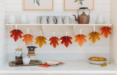 there are some paper leaves hanging on the shelf