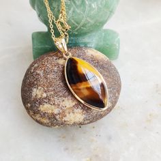 "You can choose your own gem in my store. Let me know if you would like to see options Gemstone: Brown YellowTiger Eye Gold Purity : Guaranteed 14kt pure GOLD Gem weight 9.60 carats Gem shape: Marquis Cabachon shape Gold weight: 0.56 grame Total weight: 2.48 grame The Gemstone in this pendant is ethically sourced and is exploitation free. Brown Yellow Tiger Eye is a beautiful Gemstone of patterns like no other Gemstone. Please note that the pendant is made with absolutely pure 14kt Gold. Pendant Yellow Gold Cabochon Teardrop Pendant Necklace, Teardrop Pendant Jewelry With Bezel Setting, Gift Jewelry With Bezel Setting In Teardrop Pendant Shape, Gift Jewelry Teardrop Pendant With Bezel Setting, Marquise Gemstone Necklace For Gift, Gift Teardrop Pendant Jewelry With Bezel Setting, 14k Gold Pendant Gemstone For Gift, Yellow Gold Gemstones With Bezel Setting, 14k Gold Cabochon Jewelry As Gift