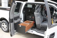 the interior of a white van with its doors open and drawers in front of it