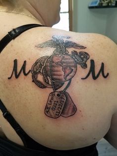 the back of a woman's shoulder with a marine tattoo on her arm and chest