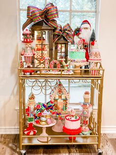 a gold serving cart filled with cakes and candy