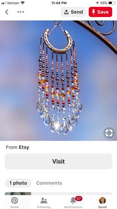 a close up of a wind chime hanging from a metal pole with blue sky in the background