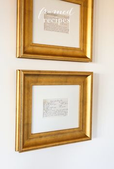 two framed pictures hanging on the wall with writing in gold frames next to each other