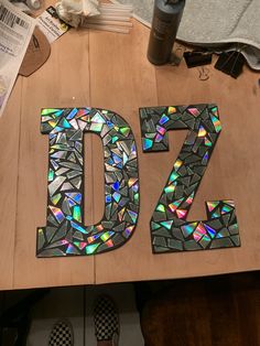 the letters d and z are made out of stained glass shards on a table top