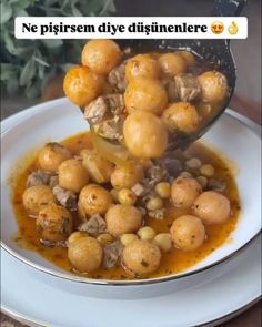 a spoon full of food sitting on top of a white plate