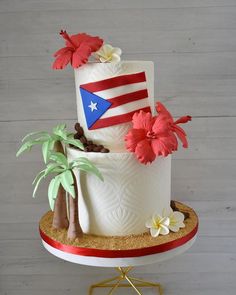 a three tiered cake decorated with flowers and an american flag on the top layer