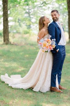 a bride and groom pose for a photo in front of the trees at their wedding