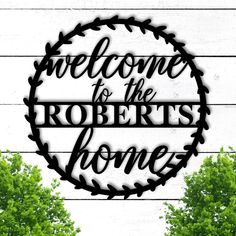 a metal sign that says welcome to the robert's home with trees in the background