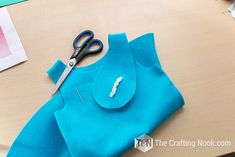 a pair of scissors sitting on top of a blue shirt