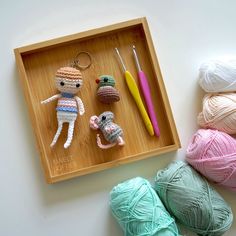 crochet items displayed on wooden tray with yarn and ball of yarn next to them