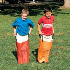 two young boys standing next to each other in the grass