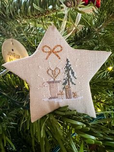 a christmas ornament hanging from a tree with a star shaped ornament