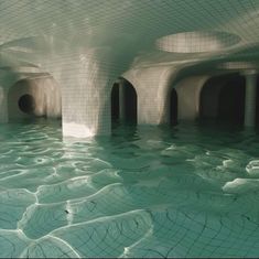 the inside of an underground swimming pool with water flowing from it's walls and floor