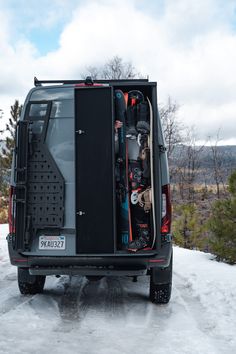 the back end of a van with skis and snowboards in it's cargo compartment