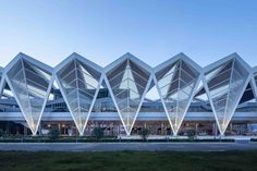 an architecturally designed building is lit up in the evening sun with its triangular roof