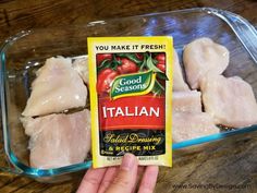 someone is holding up some raw chicken in a plastic container with the label on it