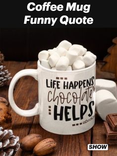 a coffee mug filled with marshmallows on top of a wooden table