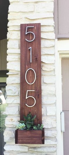 a house number sign with succulents on it