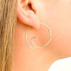 * Sterling silver spiral earrings. Also available in 14K gold filled and 14K rose gold filled. * Made with 19 gauge. Comes as a pair. * 28mm diameter. * Hand hammered texture (hammered on one side). ** Nickel free ** These thick hammered spiral hoop earrings feature a mesmerizing spiral design that will add a touch of whimsy to your look. The hand-hammered texture adds dimension and catches the light beautifully, making these earrings a statement piece. The thickness of the hoops gives them a substantial weight, while the spiral shape creates a flattering silhouette. Crafted from high-quality sterling silver, these hoop earrings are built to last. These spiral earrings are a must-have for any jewelry lover who appreciates a unique twist on a classic style. Our jewelry is packaged in a cute Spiral Nickel-free Hoop Earrings For Everyday, Modern Spiral Hoop Earrings As Gift, Everyday Spiral Earrings With Ear Wire, Spiral Hypoallergenic Hoop Earrings, Swirl Shaped Nickel-free Hoop Earrings As Gift, Nickel-free Spiral Wrap Earrings, Nickel-free Spiral Hoop Earrings As Gift, Nickel-free Swirl Hoop Earrings Gift, Swirl Hoop Earrings Nickel Free Gift