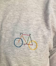 a close up of a person wearing a sweatshirt with a bike embroidered on it