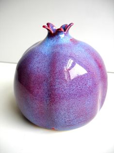 a purple vase sitting on top of a white table