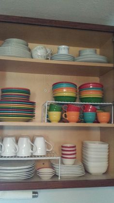 the shelves are filled with colorful dishes and plates, including one that is stacked on top of each other