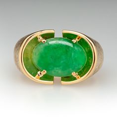 This fantastic ring is centered with one (1) oval cabochon cut natural jadeite jade set into a four-prong setting. The top half of the ring has a Florentine finish. One shoulder of the ring is engraved with initials. The ring measures 14.8mm at the top, rises 5.9mm above the finger, tapering to 4.3mm wide and 1.2mm thick at the base of the shank. This ring is currently a size 10.75. There are initials engraved on one of the shoulders in the textured gold. Formal Oval Jade Emerald Ring, Modern Oval Jade Jewelry, Jade Rings With Polished Finish, Oval Cabochon, Jade Rings With Polished Finish In Oval Cabochon Shape, Oval Cabochon Jade Rings With Polished Finish, Jade Oval Cabochon Rings With Polished Finish, Modern Oval Jade Ring, Classic Oval Chrysoprase Ring, Modern Green Oval Cabochon Jewelry