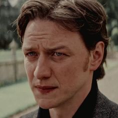 a close up of a person wearing a suit and tie looking at the camera with an intense look on his face