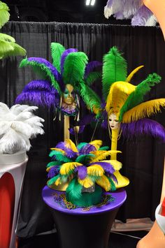 there are many colorful hats on display in the store's showroom, and one is wearing a mask with feathers