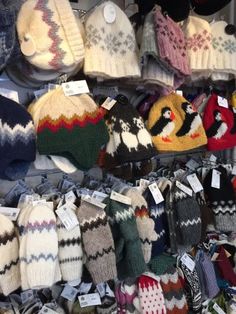 many hats and mittens are on display at the store for $ 10 each or more