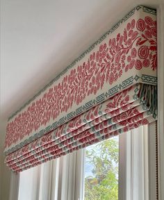 a red and white roman blind in front of a window