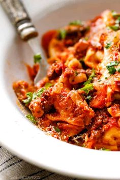 a white bowl filled with pasta and sauce