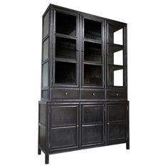 a black bookcase with glass doors and drawers on the bottom shelf is shown against a white background