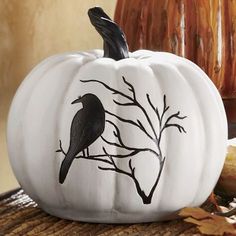 a white pumpkin with a black bird painted on it