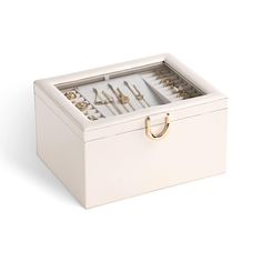 an open white box with jewelry in it on a white surface and the lid opened