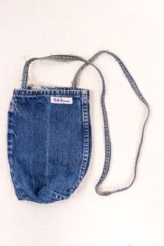 an old pair of blue jean shorts is hanging on a white background with a cord