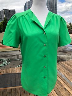 "Lady Arrow- Mistique. Made in America. No size or material tags. Material is super soft, smooth and lightweight. Possible polyester. Good condition; no notable flaws. Estimated size S/M. Measurements: Shoulders seam to seam:14.75\" Sleeve length:9\" pit to pit:19\" across waist:17.75-18\" length:24\"-25\"" Vintage Blouse With Puff Sleeves And Button Closure, Retro Top With Buttons, Vintage Solid Color Blouse For Daywear, Retro Green Blouse With Button Closure, Retro Green Blouse With Buttons, Short Puff Sleeve Blouse, Blouse Western, Short Puff Sleeve, Green Soft