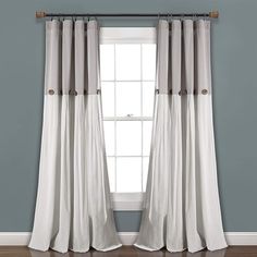 the curtains are hanging in front of a window with blue walls and hardwood floors,