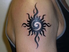 a black and white photo of a sun tattoo on someone's left upper arm