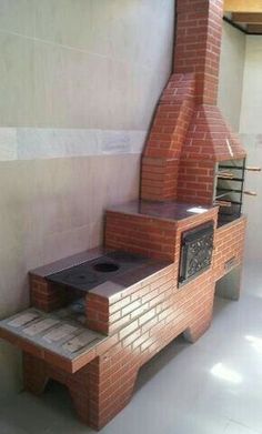 a brick oven sitting on top of a wooden bench next to a white tiled wall